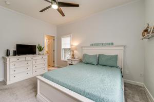 Un dormitorio con una cama y un televisor de pantalla plana. en Coastal Gem 3 half Mi from Wrightsville Shoreline, en Wilmington