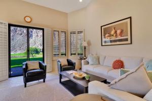 a living room with a couch and a table at Spacious Villa with Spectacular Golf Course Views in La Quinta