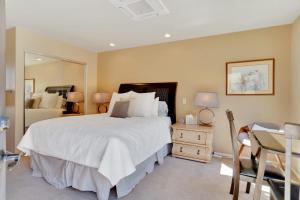 a bedroom with a large white bed and a mirror at Golf Course Villa with Exceptional Views in La Quinta
