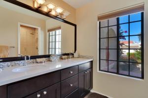 a bathroom with a sink and a large mirror at Golf Course Villa with Exceptional Views in La Quinta +39 photos