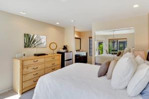 a bedroom with a large white bed and a kitchen at Golf Course Villa with Exceptional Views in La Quinta