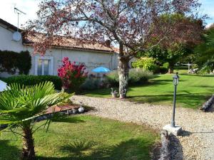 a yard with a house with a tree and a street light at Grand Gîte Familial avec Piscine Chauffée, Wi-Fi et Animaux Bienvenus - FR-1-653-272 in Angeduc