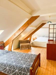 a attic bedroom with a bed and a couch at Gîte "Le 108" à 700m du port de Saint-Vaast-la-Hougue in Saint-Vaast-la-Hougue