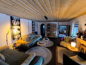 a living room with a couch and chairs and tables at Blue Forest Retreat in Mánfa