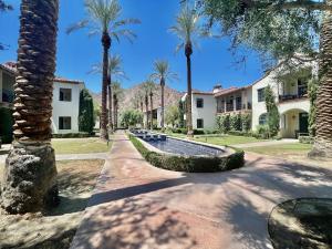 un patio con palmeras y una piscina en Gorgeous Ground Floor Villa Near Main Pool, en La Quinta