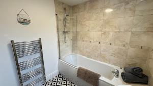 a bathroom with a shower and a bath tub at Sea Blue House, Cullercoats in Cullercoats +32 photos