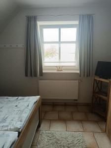 a bedroom with a bed and a window at Marschblick in Südermarsch