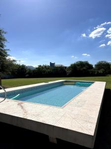 a large swimming pool with a tile floor at Quinta lo de Dito in Villa Allende