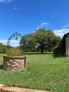 a stone wall with a flower pot in a field at Quinta lo de Dito in Villa Allende +32 photos