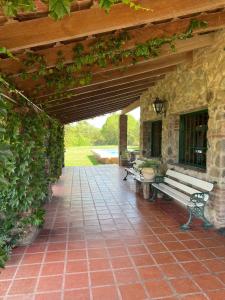 a patio with a bench and a stone wall at Quinta lo de Dito in Villa Allende