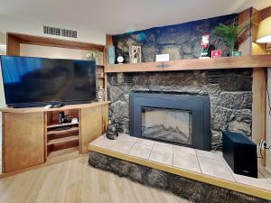 a living room with a fireplace and a tv at The Crows Nest in Ruidoso