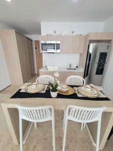 a kitchen with a table and two white chairs at Condo en el corazon de Playa del Carmen in Playa del Carmen