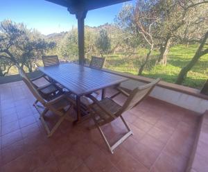 a wooden table and chairs on a patio with a view of a mountain at Cicero’s - Intero alloggio in Castelbuono +39 photos