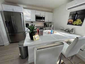 a kitchen with a counter with a sink and a refrigerator at Modern Apartment Miami Oasis in Miami