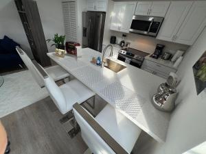 a kitchen with a large white counter top with white cabinets at Modern Apartment Miami Oasis in Miami +15 photos