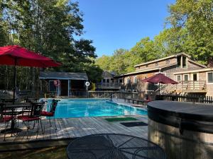 a swimming pool with tables and chairs and umbrellas at The Pine Lodge in Northport