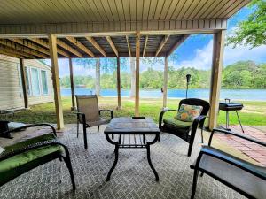 un porche cubierto con mesa y sillas en Clearwater Luxe!, en Hot Springs