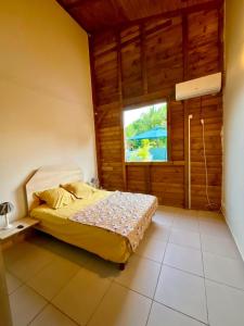 a bedroom with a bed in a room with a window at Villa Rêve Créole in Le Moule