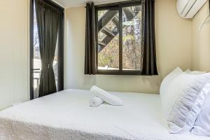 a bedroom with a white bed with a window at 5 Mi to Stone Mountain Lithonia Getaway in Lithonia