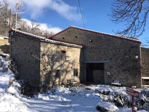 a large stone building in the snow with a garage at El Embalse in Los Loros