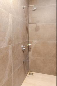 a shower with a glass door in a bathroom at Scenic Apartment in Khaira Gali in Abbottābād