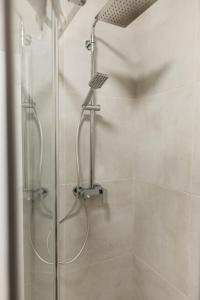 a shower with a glass door in a bathroom at Macao Apartmani in Vinkovci