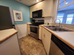 a kitchen with a sink and a stove top oven at North Shore Inn TC 308 in Traverse City