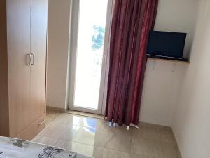 a room with a large window and a television at Apartments Pehar in Zaostrog