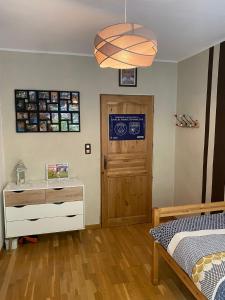 a bedroom with a bed and a dresser and a door at Gîte mon chez moi in Soucht