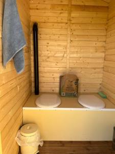 a sauna with two toilets in a wooden wall at Peaceful eco glamping cabin in Pauntley