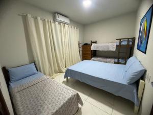a small bedroom with two beds and a window at Casa Temporada Aconchego e tranquilidade 3 in Bonito +8 photos