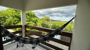 a hammock in a room with a balcony with a view at Casa Temporada Aconchego e tranquilidade 3 in Bonito