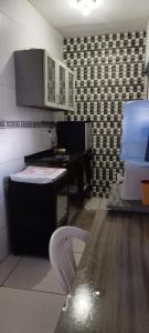 a kitchen with a table and a piano in a room at Kitnet para Hospedagem in Caruaru