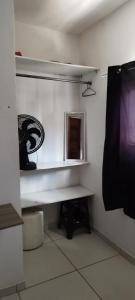 a room with a desk and a mirror in a room at Kitnet para Hospedagem in Caruaru