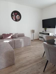 a living room with a couch and a flat screen tv at Apartments Grdelin in Trogir