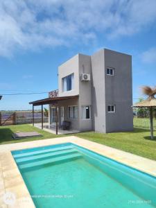 ein Haus mit einem Swimmingpool davor in der Unterkunft Complejo Las Cabañas del Lago in Mar de Cobo