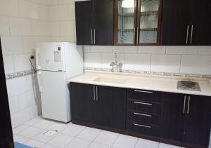 una cucina con un frigorifero bianco e un lavello di فندق أصالة الحمراء a Gedda