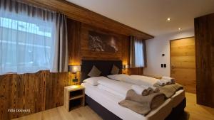 a bedroom with a large bed and a large window at Villa Dolomiti in Ortisei