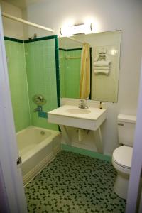 a bathroom with a sink and a tub and a toilet at El Camino Motel in Tallahassee +22 photos