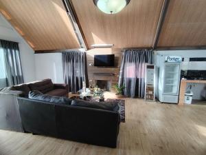 a living room with a couch and a tv at Cabaña Falda del Volcán Barú Planta alta in Paso Ancho +25 photos