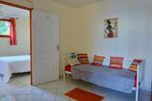 Un dormitorio con una cama con almohadas encima. en colibri, en Bouillante