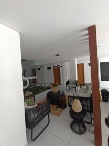 ein Wohnzimmer mit Stühlen und einem Sofa in der Unterkunft Flet em Porto de Galinhas - Varandas do Porto in Porto De Galinhas + 5 Fotos