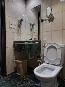 a bathroom with a toilet and a sink and a mirror at فندق رفاق العالية in Makkah