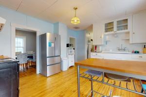 Green Door Cottage في Weston: مطبخ به ثلاجة وطاولة بداخله