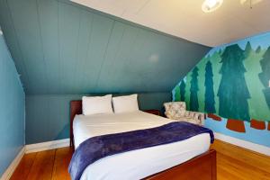 a bedroom with a bed and a blue wall at Green Door Cottage in Weston