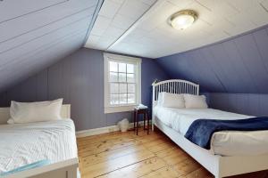 Green Door Cottage في Weston: سريرين في غرفة بجدران زرقاء