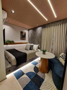 a bedroom with two beds and a table in it at Metrô Studio Alto do Ipiranga in São Paulo