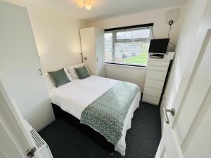 a small bedroom with a bed and a window at 2 Bedroom Chalet SB172, Sandown Bay, Isle of Wight, Free WiFi in Isle of Wight