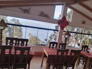 a dining room with a table and chairs and a large window at Palacio del Inca Lodge in Comunidad Yumani