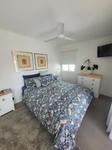 a bedroom with a bed with a blue comforter at Best location on the river in the beautiful Islander Resort in Noosaville +10 photos